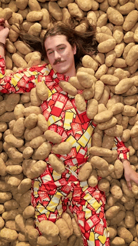 Schwierige Entscheidungen sind wie eine heiße Kartoffel Mann liegt in vielen Kartoffeln