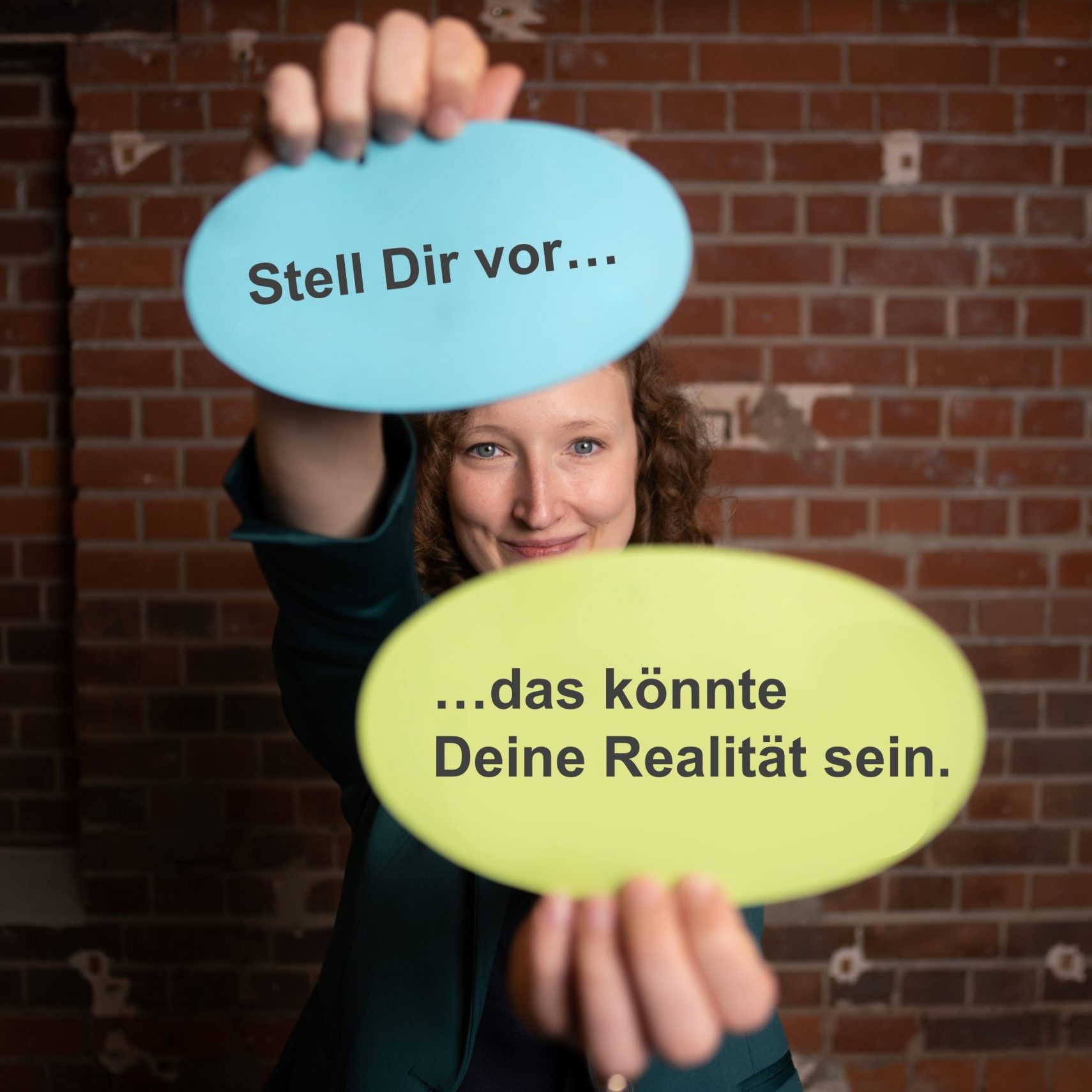 stell dir vor... Julia Leppin hält zwei Moderationskarten, auf denen steht: das könnte Deine Realität sein